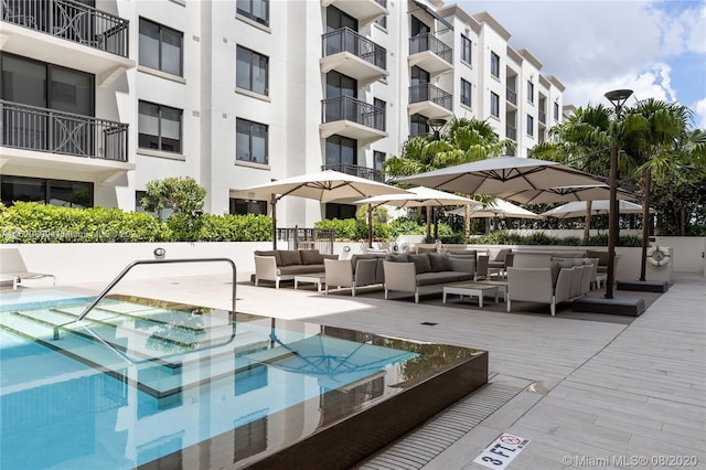 view of pool with a hot tub and an outdoor hangout area