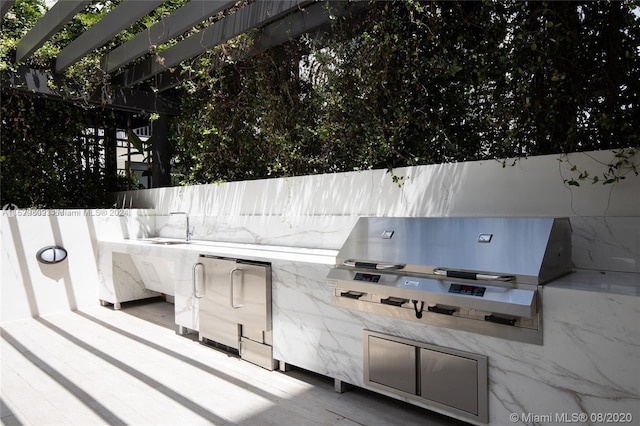 view of patio featuring exterior kitchen and a grill