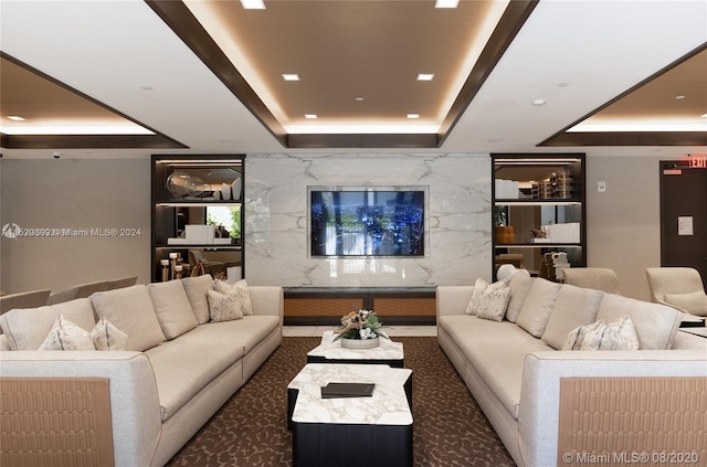 carpeted living room with a tray ceiling