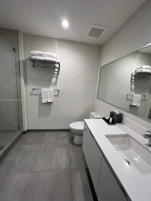 bathroom featuring walk in shower, tile flooring, vanity with extensive cabinet space, and toilet