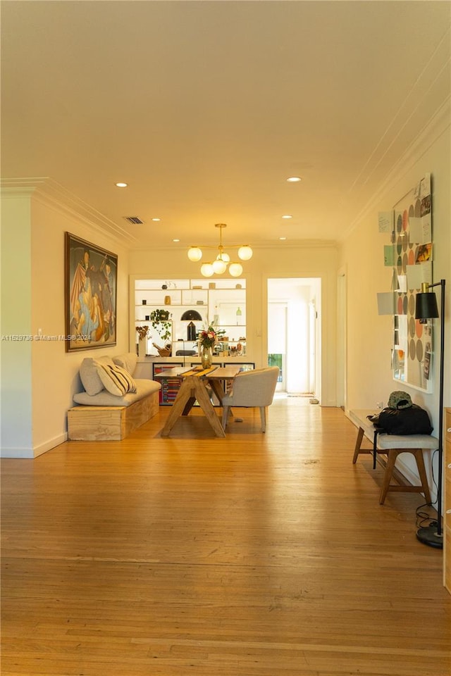 living room featuring ornamental molding, a chandelier, and hardwood / wood-style flooring