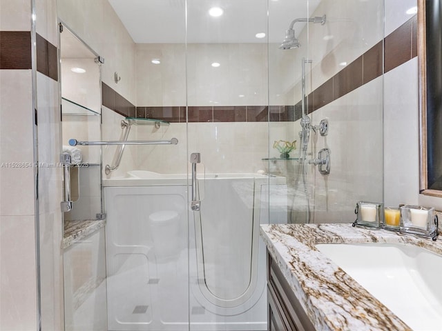 bathroom with vanity and a shower with shower door