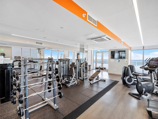 gym with french doors, floor to ceiling windows, and a wealth of natural light