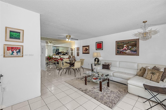 living room with light tile floors, a textured ceiling, and ceiling fan with notable chandelier