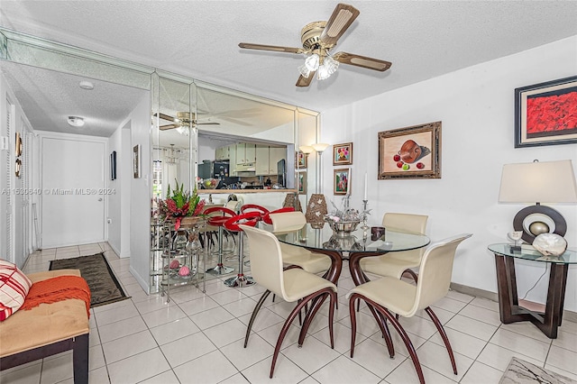 dining space featuring light tile floors, ceiling fan, and a textured ceiling