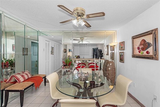 tiled dining area with a textured ceiling and ceiling fan