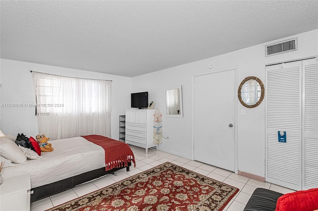 tiled bedroom with a textured ceiling