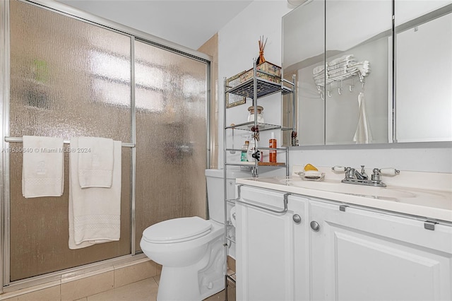 bathroom with toilet, tile floors, a shower with shower door, and vanity with extensive cabinet space