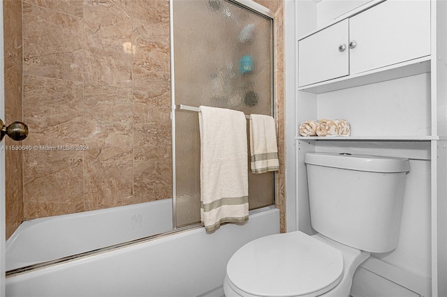 bathroom with enclosed tub / shower combo and toilet