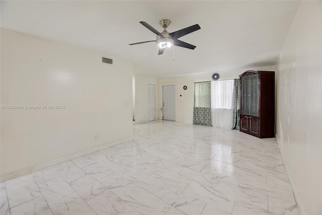 tiled spare room with ceiling fan