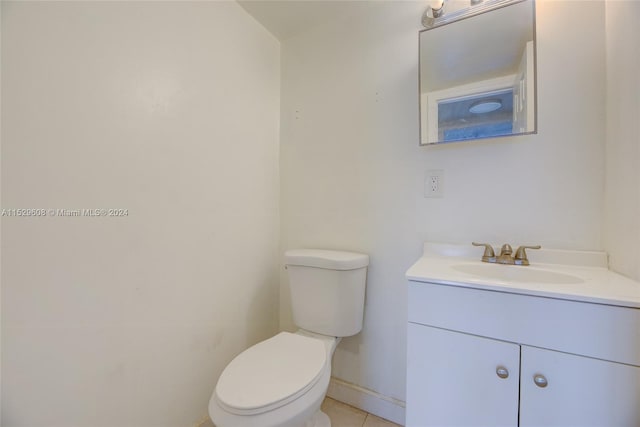 bathroom with toilet, tile flooring, and vanity