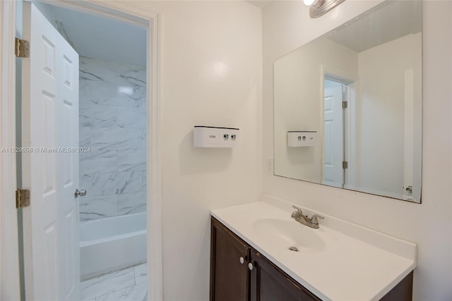 bathroom with tile flooring, tiled shower / bath combo, and vanity