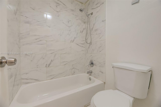 bathroom featuring toilet and tiled shower / bath