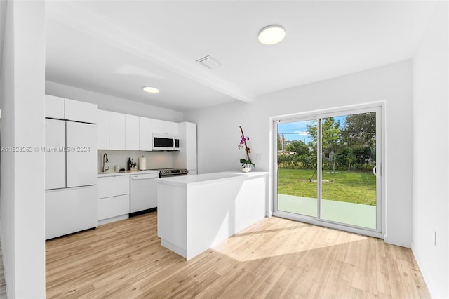 kitchen featuring white appliances, sink, kitchen peninsula, light wood-type flooring, and white cabinetry