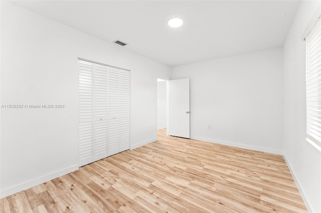 unfurnished bedroom with a closet and light wood-type flooring