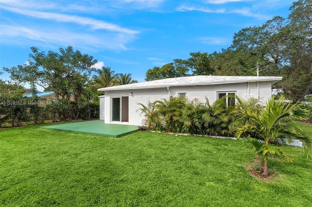 back of property featuring a patio and a lawn