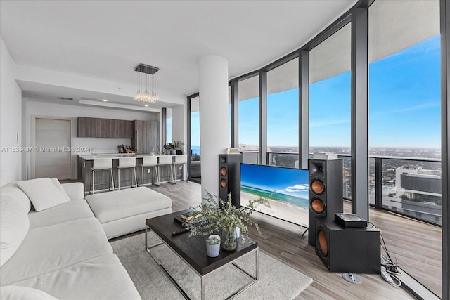 living room featuring expansive windows, light hardwood / wood-style floors, and an inviting chandelier