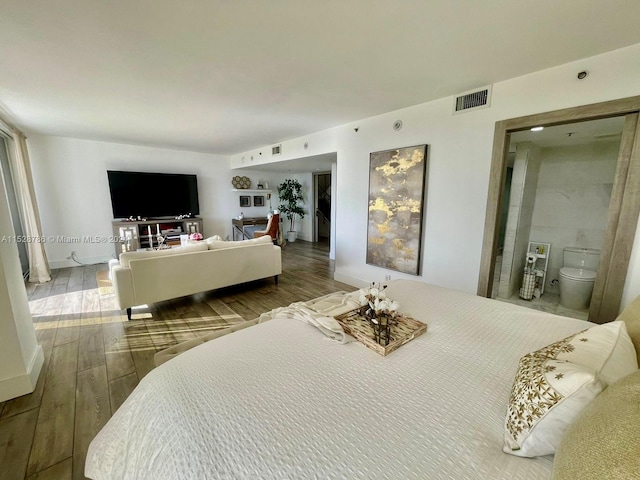 bedroom featuring dark hardwood / wood-style floors and connected bathroom