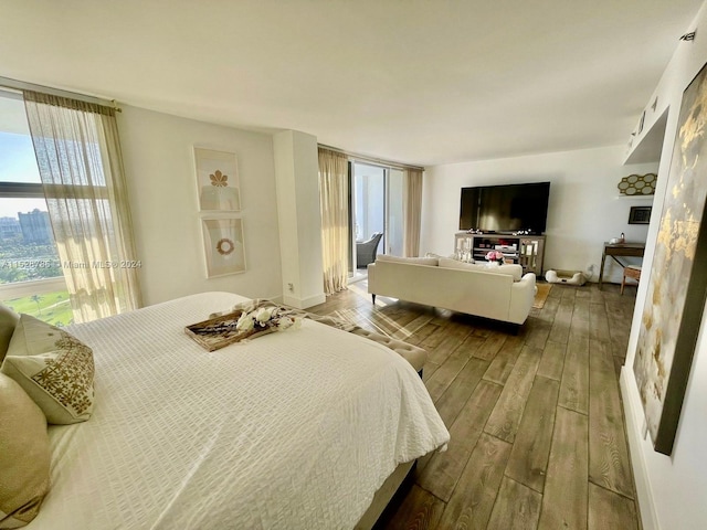 bedroom with hardwood / wood-style floors and a wall of windows