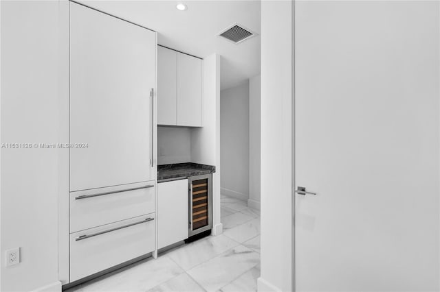 kitchen featuring white cabinetry, light tile floors, and wine cooler