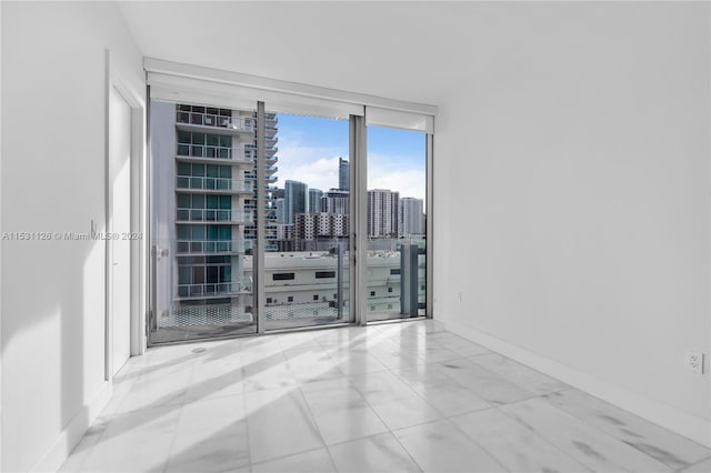 empty room with light tile floors and expansive windows