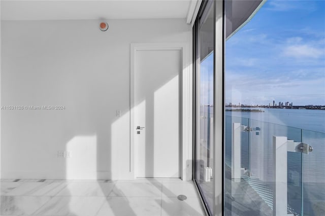 interior space featuring light tile floors and a water view