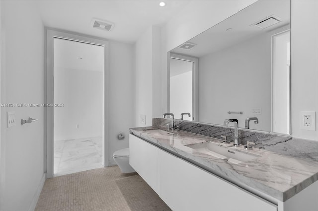 bathroom with oversized vanity, toilet, tile floors, and double sink