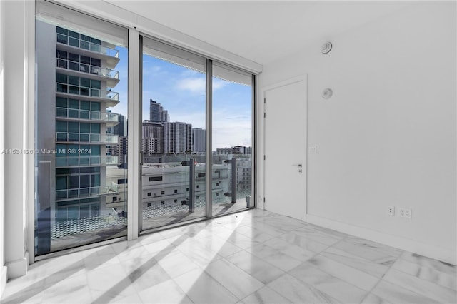 empty room with light tile floors and expansive windows