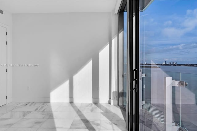 interior space featuring light tile flooring and a water view