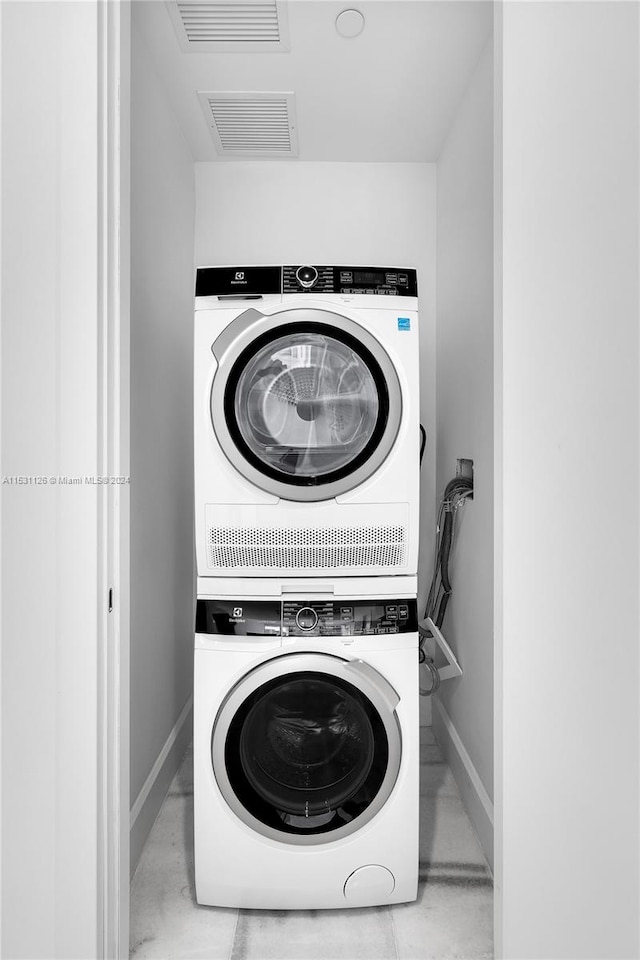 washroom featuring stacked washer and clothes dryer