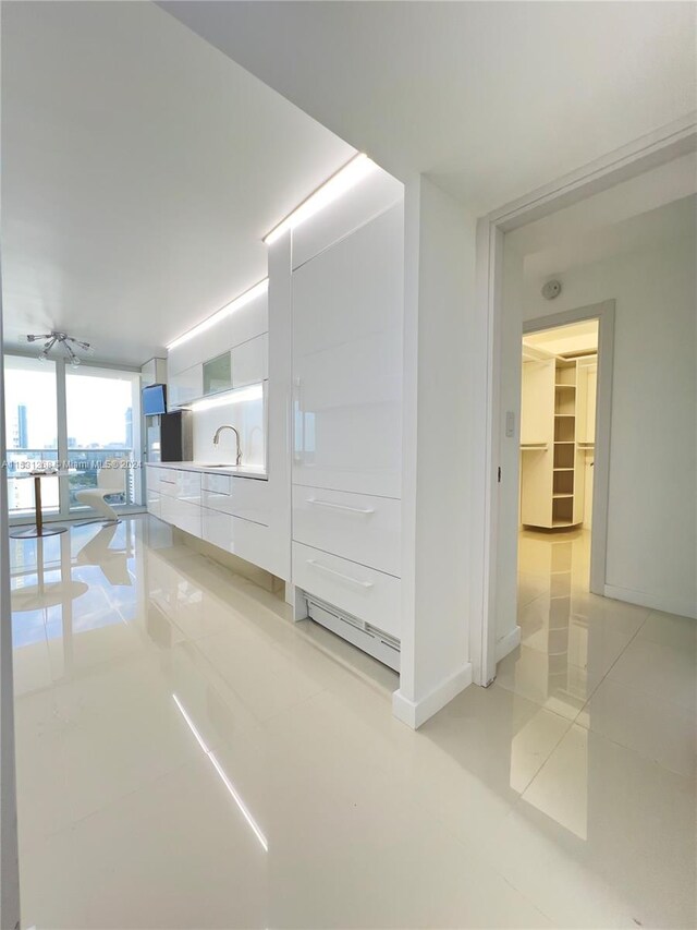 interior space with floor to ceiling windows and light tile flooring