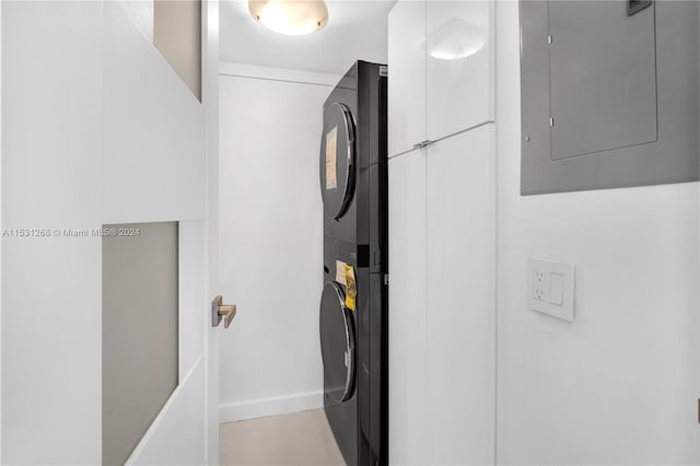 clothes washing area featuring stacked washer / dryer