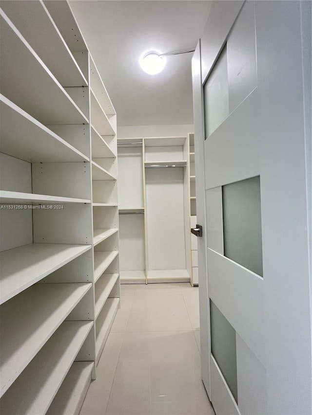 walk in closet featuring light tile floors