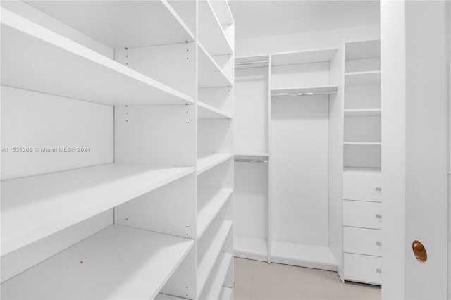 walk in closet featuring light tile flooring