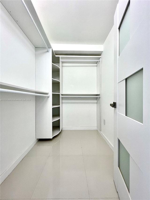 walk in closet featuring light tile flooring