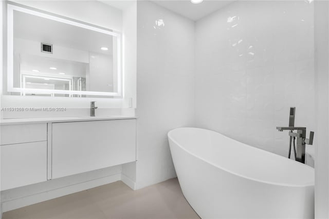 bathroom with tile flooring, vanity, and a bathing tub