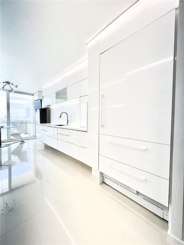 interior space featuring sink and white cabinetry