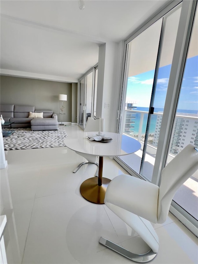 dining space featuring tile flooring, a water view, and expansive windows