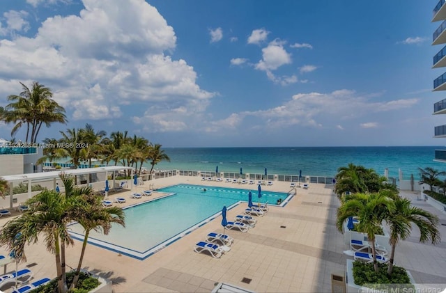 view of swimming pool with a water view and a patio area