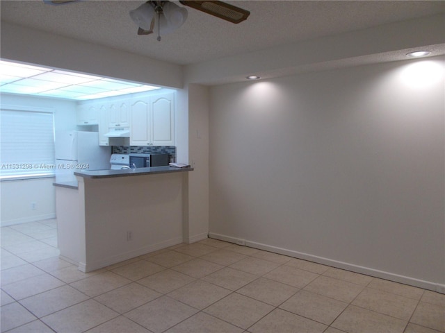 kitchen featuring white cabinetry, kitchen peninsula, white fridge, ceiling fan, and light tile patterned floors