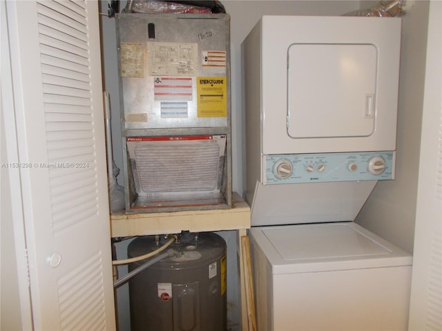 laundry room featuring heating unit and stacked washer / dryer