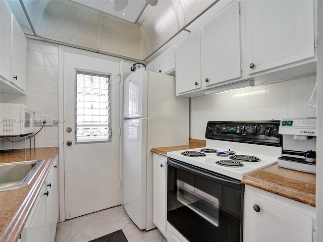 kitchen featuring white appliances, sink, light tile flooring, tasteful backsplash, and white cabinetry