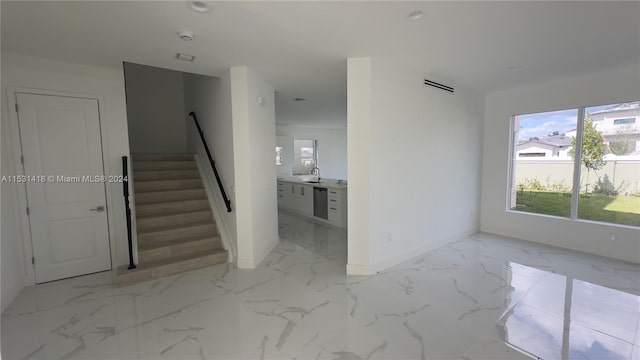 unfurnished living room with sink and light tile floors