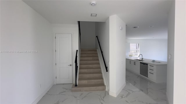 staircase featuring sink and light tile flooring