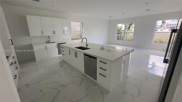 kitchen with white cabinets, sink, light tile floors, and a kitchen island with sink