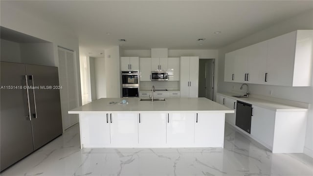 kitchen with sink, white cabinets, a center island with sink, and stainless steel appliances