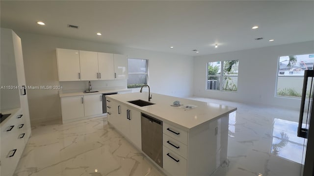 kitchen with an island with sink, dishwasher, light tile floors, sink, and white cabinets