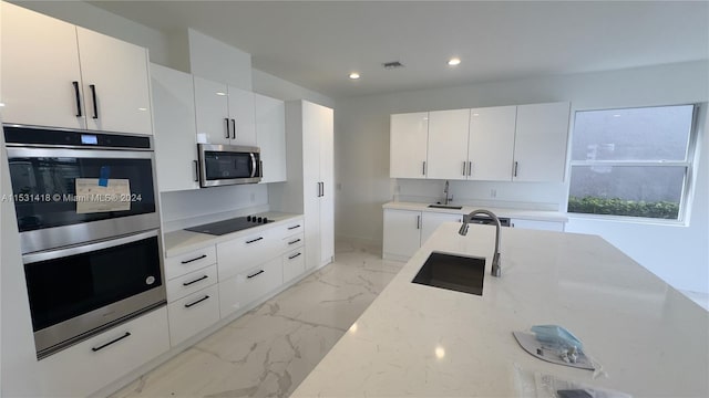 kitchen with sink, white cabinets, light tile flooring, and appliances with stainless steel finishes