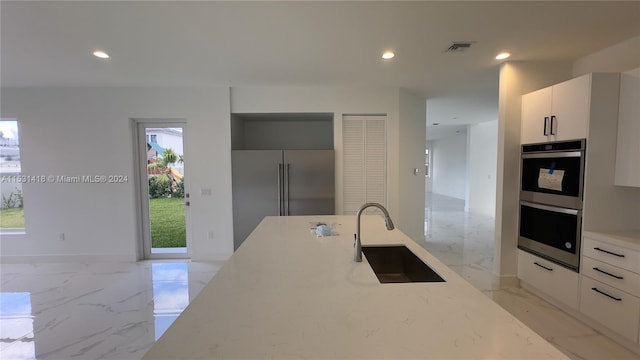 kitchen featuring white cabinetry, appliances with stainless steel finishes, sink, and a wealth of natural light