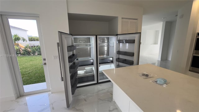 kitchen featuring stainless steel oven and light tile floors